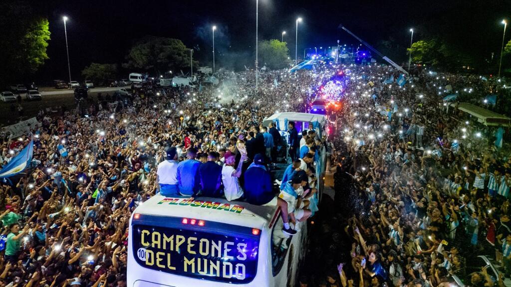 L'équipe nationale d'Argentine à bord d'un bus entouré de supporters, après avoir été sacrée championne de la Coupe du monde 2022 au Qatar. Buenos-Aires, le 20 décembre 2022.