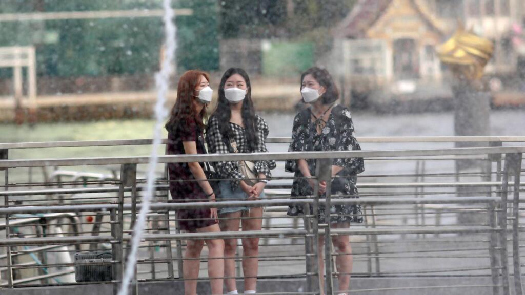 Des touristes portent des masques alors qu'ils visitent un centre commercial à Bangkok, en Thaïlande, le 30 janvier 2020.