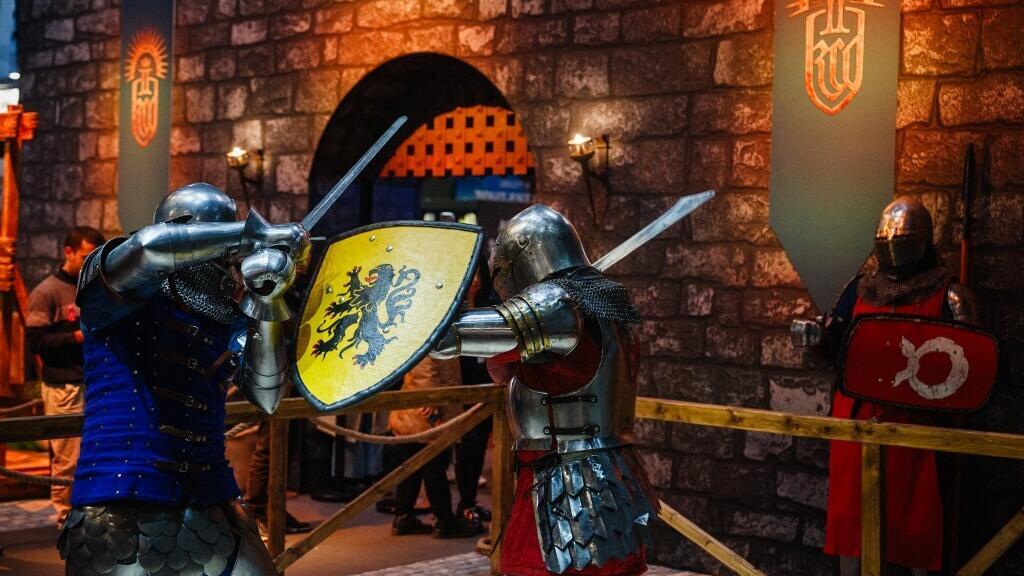 Des participants vêtus de costumes de chevalier effectuent un combat au salon « Paris Games Week » à Paris, le 23 octobre 2024.