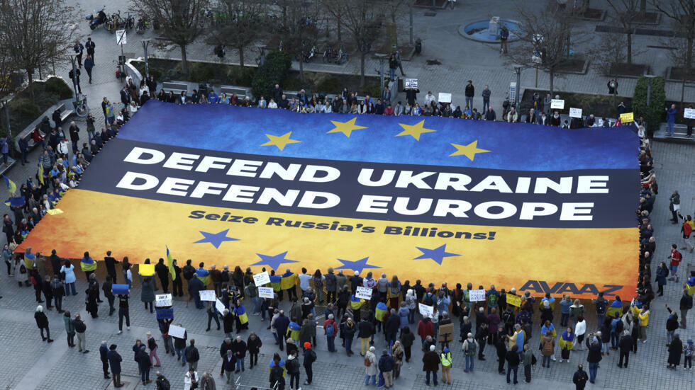 Activists unfurl a large banner in support of Ukraine outside the European Council building ahead of an EU summit in Brussels, Belgium, Wednesday, March 5, 2025.