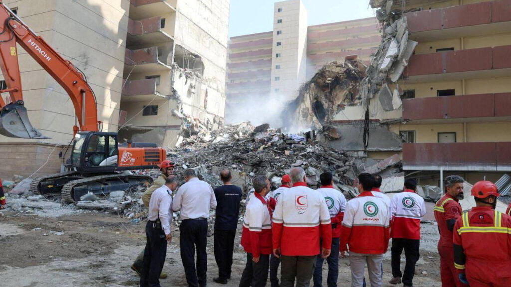 Des sauveteurs travaillent sur le site d'un bâtiment endommagé, à la suite des frappes israéliennes, à Téhéran, en Iran, le 13 juin 2025.