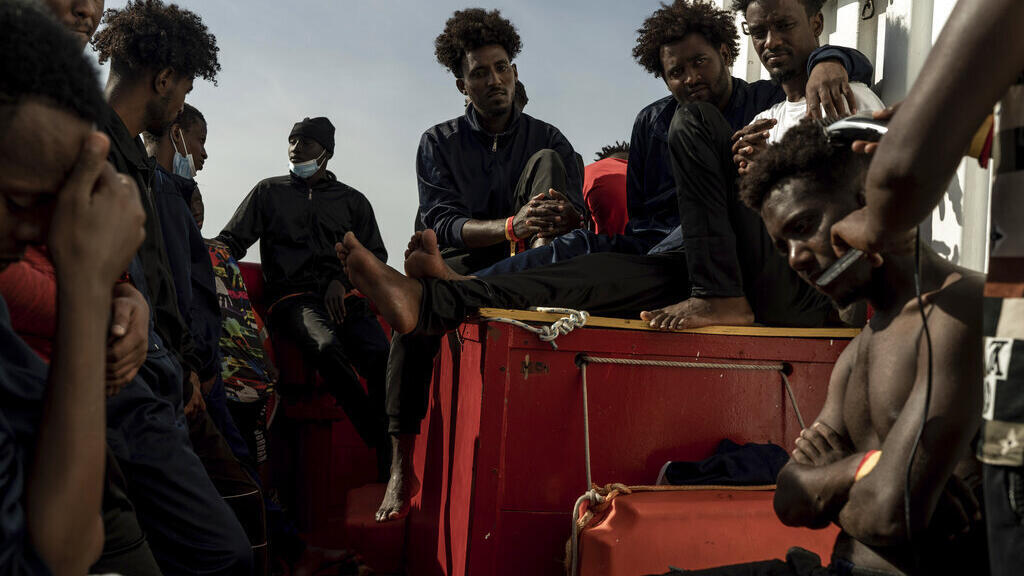 Alguns dos migrantes resgatados do mar são vistos a bordo do navio humanitário Ocean Viking no Mar Mediterrâneo, quarta-feira, 9 de novembro de 2022.
