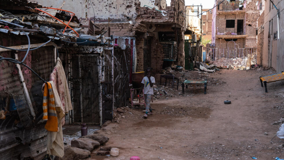 Msichana huyu akitembea karibu na nyumba zilizoharibiwa katika kitongoji cha Wad Nubawi, ambacho kiliharibiwa vibaya kufuatia miezi kadhaa ya mapigano kati ya jeshi la Sudani (SAF) na RSF, Oktoba 24, 2024 huko Omdurman.