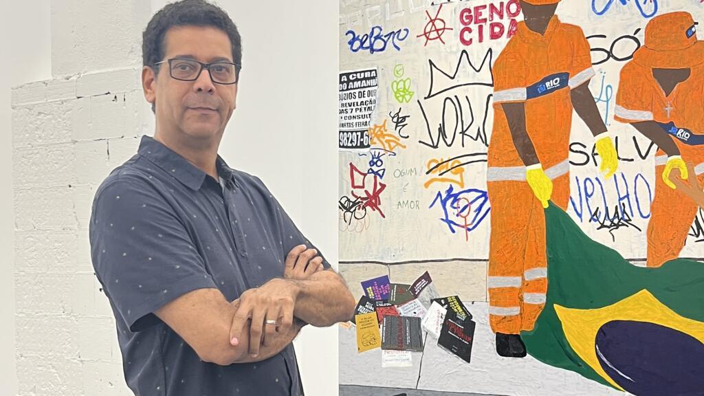 O artista visual brasileiro Osvaldo Carvalho, vencedor do Breeze Award 2023, diante de sua obra Os Negacionistas.