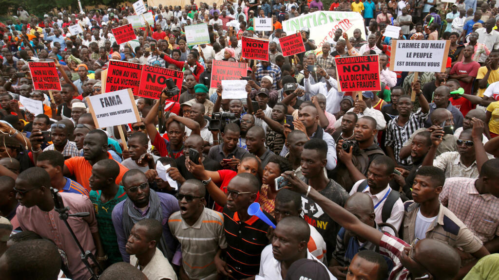 Des manifestations brandissent des pancartes dénonçant des fraudes supposées lors du premier tour l'élection présidentielle malienne, à Bamako, à la veille du second tour, le 11 août 2018.