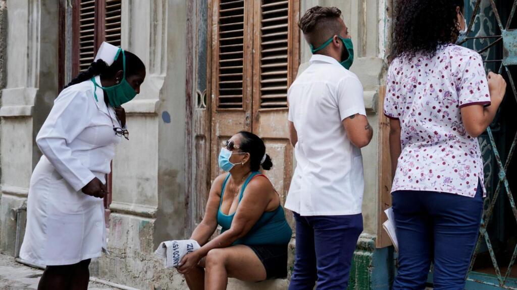 Des étudiants en médecine font du porte-à-porte à la recherche de personnes qui présenteraient des symptômes du Covid-19, afin de stopper la propagation de l'épidémie. Photo prise à La Havane, Cuba, le 11 mai 2020.