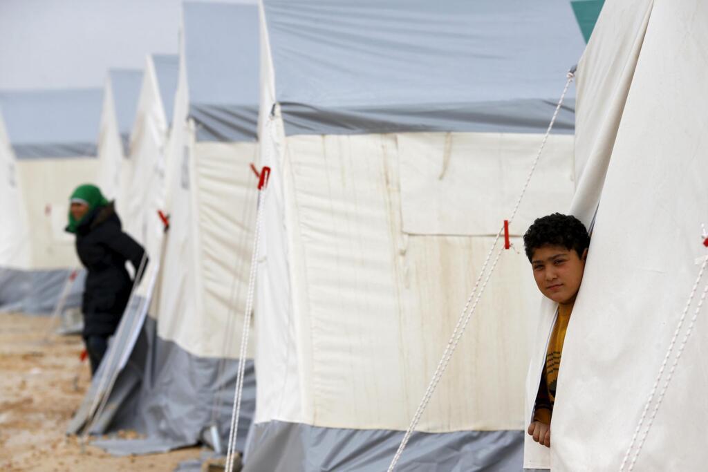 A boy looks out from his tent at a refugee camp near the Bab al-Salam border crossing between Syria and Turkey, on the outskirts of the northern Syrian border town of Azaz, on 6 February 2016.