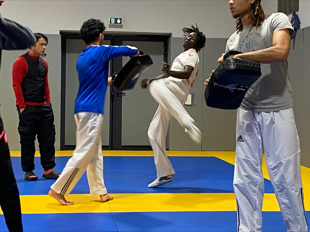 Casimir Betel tape dans un pao lors de son entrainement de taekwondo.