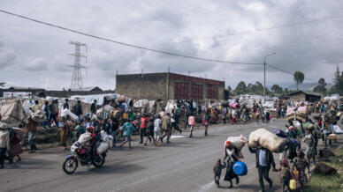 War-displaced people flee towards the city of Goma, eastern Republic of Congo, on November 15, 2022. - Thousands of displaced people began to flee after soldiers retreated to Kanyarushinya, an informal camp of over 40,000 people in the northern district of Goma. Troops in the Democratic Republic of Congo (DRC) were battling M23 fighters in Kibumba, 20 kilometres (12 miles) north of Goma, security officials and local residents said. The M23 militia has recently surged across the Democratic Republic of Congo's North Kivu province, capturing swathes of territory and inflaming tensions with neighbouring Rwanda.