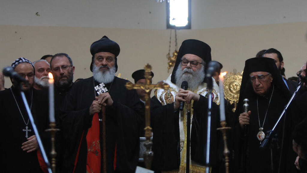Mar Ignatius Aphrem II (à gauche), patriarche d'Antioche et de tout l'Orient de l'Église syriaque orthodoxe, se joint aux fidèles réunis pour une messe célébrée par le patriarche grec orthodoxe d'Antioche Jean X (au centre), au lendemain d'un attentat suicide contre l'église Saint-Élie dans le quartier de Dwelaa à Damas, le 23 juin 2025.