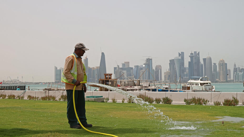 Un employé arrose la pelouse dans la capitale qatarie, Doha, le 5 mai 2022.