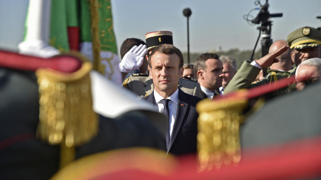 French President Emmanuel Macron reviews the honour guard upon his arrival in Algiers on December 6, 2017. (Photo by Ryad KRAMDI / AFP)