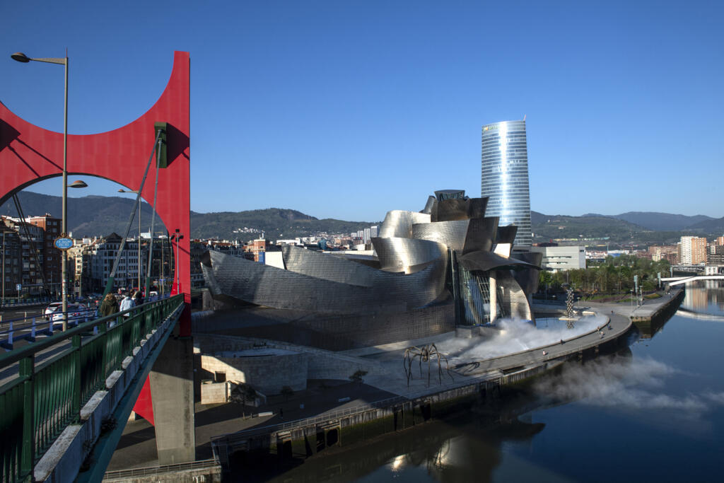 Cette photo prise le 19 avril 2023 montre une vue générale du musée Guggenheim Bilbao de l’architecte canado-américain Frank Gehry, à côté de l’œuvre de l’artiste français Daniel Buren « Arku Gorriak » (Arcs rouges) sur le pont La Salve sur la rivière Nervion dans la ville basque espagnole de Bilbao.