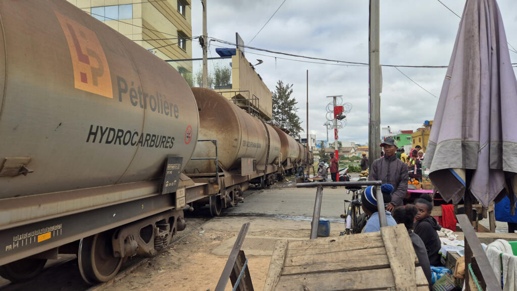 Après plus de 20h de trajet, le train chargé de wagons-citernes remplis de gasoil fait son entrée dans la capitale. Malgré sa faible vitesse (10km), le conducteur de la locomotive garde les doigts vissés sur le klaxon pour alerter les Tananariviens du danger.