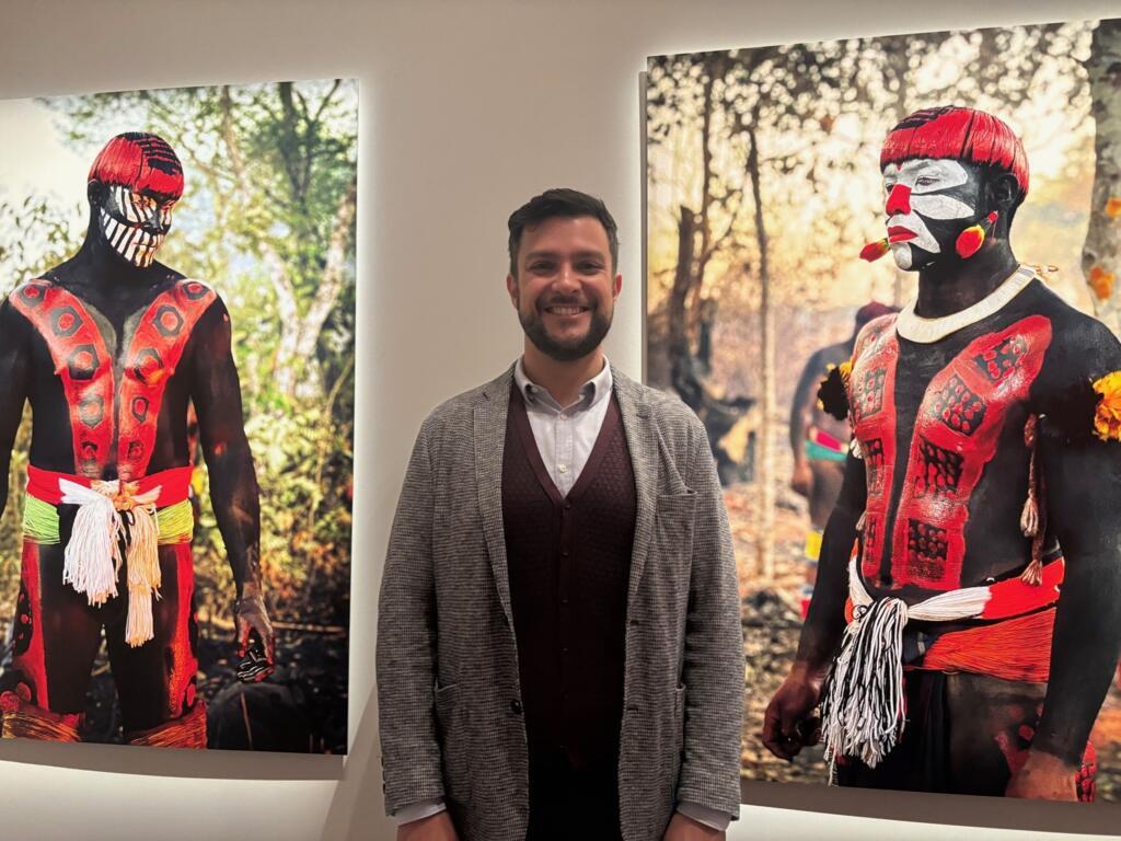 Leandro Varison, um dos curadores de "Amazônia", entre fotografias feitas por Iano Mac Yawalapiti, no Xingu, exibidas no Museu do Quai Branly, em Paris, em 29 de setembro de 2025.