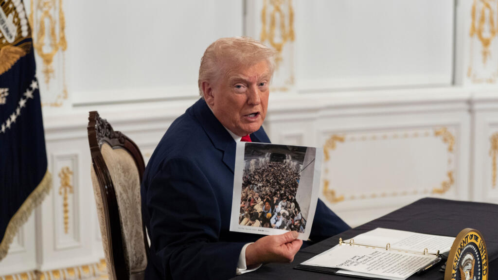 Tổng thống Mỹ Donald Trump giơ cao một bức ảnh khi phát biểu với các phóng viên sau khi nói chuyện với binh lính qua video từ khu bất động sản Mar-a-Lago của mình vào ngày Lễ Tạ ơn tại Palm Beach, bang Florida, Hoa Kỳ, ngày 27/11/2025.