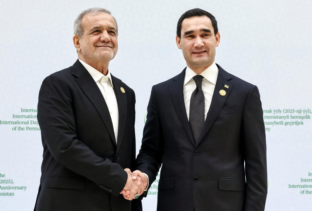 Iranian President Masoud Pezeshkian, left, and Turkmenistan's President Serdar Berdymukhamedov shake hands prior to an international forum in Ashgabat, Turkmenistan, Friday, Dec. 12, 2025. (Alexander