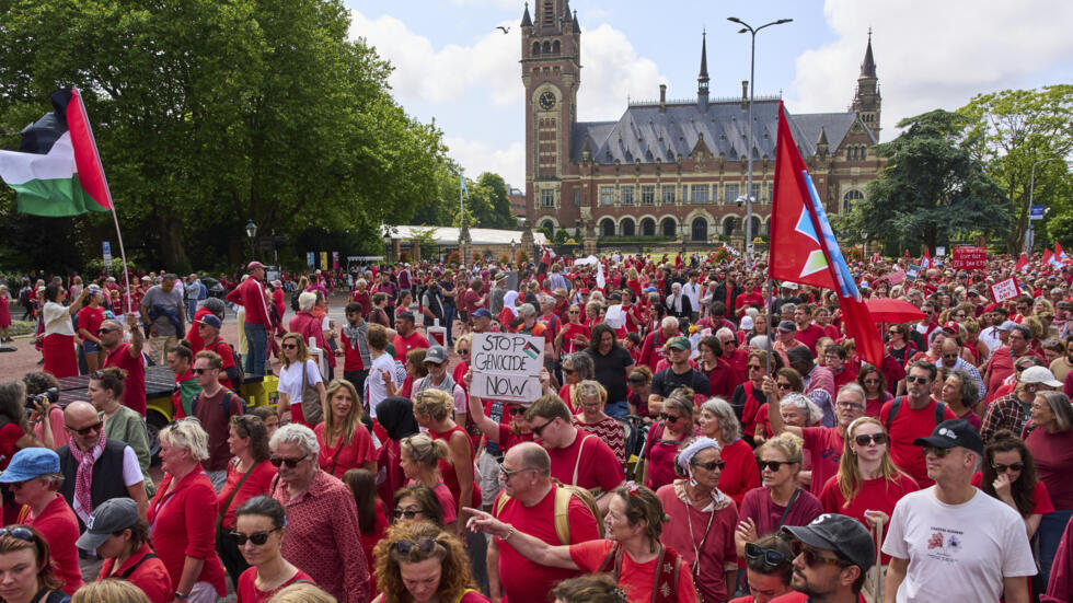 Des dizaines de milliers de manifestants vêtus de rouge ont défilé devant le Palais de la Paix, abritant la Cour internationale de Justice, exigeant que leur gouvernement fasse davantage pour mettre fin à la campagne israélienne à Gaza, lors d'une manifestation à La Haye, aux Pays-Bas, le dimanche 15 juin 2025.
