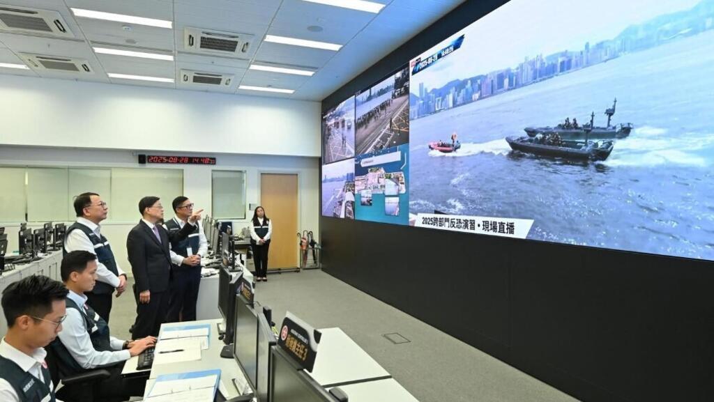 在8月底的三层反恐机制运作後之首个大型演习中，特首李家超(站立者中)与两名主要官员在政府紧急事故监察及支援中心就演习进行督导。