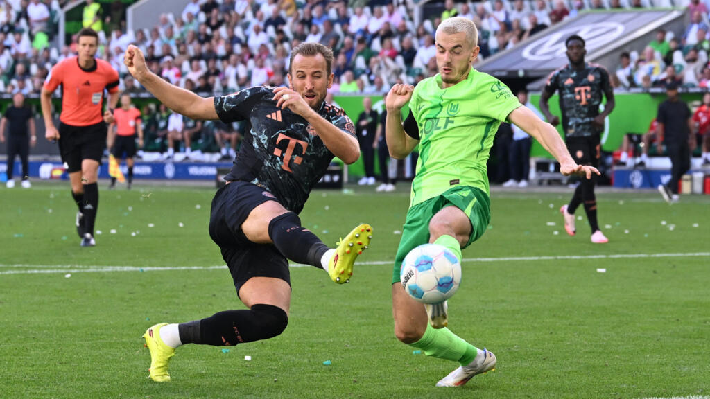 Harry Kane du Bayern Munich en action avec Jonas Wind du VfL Wolfsburg, le 25 août 2024. .