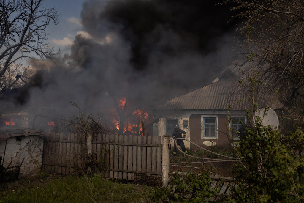 Les pompiers ukrainiens éteignent un incendie suite à une attaque russe dans le village de Tchernihivka, dans le district de Pokrovsk, en Ukraine, le 22 avril 2025.
