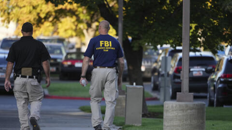 Un agent du FBI et un policier devant le campus de l'Université de la Vallée de l'Utah au lendemain de l'assassinat de Charlie Kirk, jeudi 11 septembre 2025.