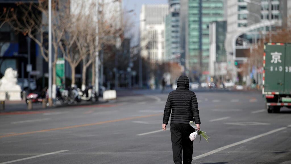 Un homme marche le long de la rue Financial, dans le centre de Pékin, en Chine, alors que le pays est frappé par l'épidémie de coronavirus, le 3 février 2020.