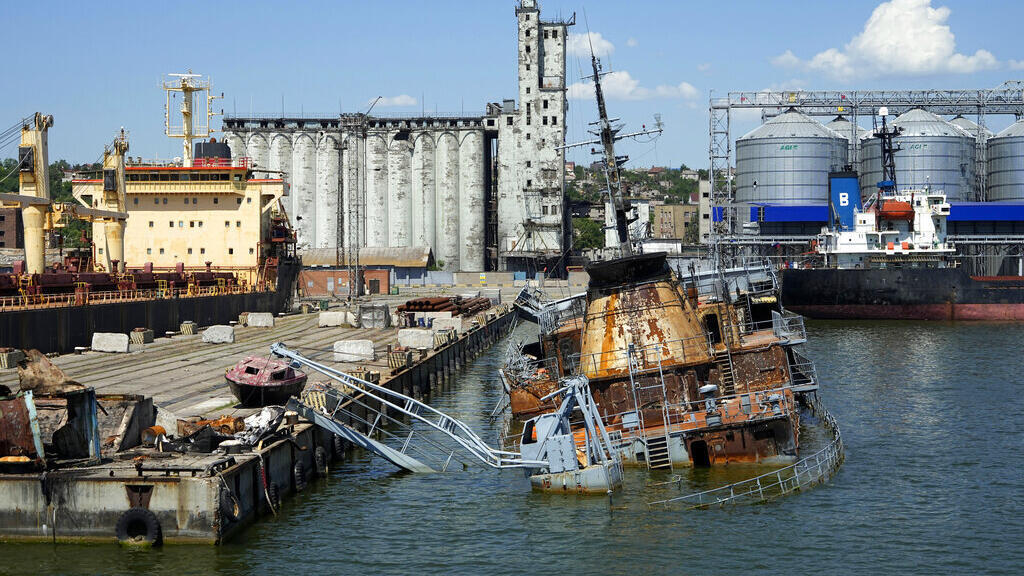Um navio de guerra ucraniano afundado perto do cais com o armazenamento de grãos ao fundo, em uma área do porto do Mar de Mariupol, em território que está sob o controle da autoproclamada República Popular de Donetsk, no leste da Ucrânia, domingo, 12 de junho de 2022.