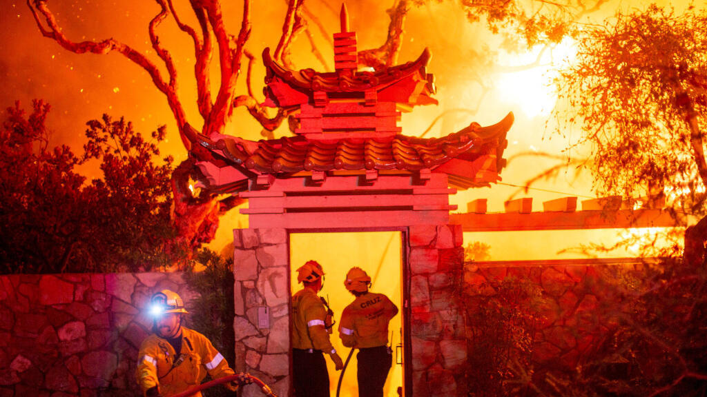 Les pompiers combattent l'incendie des palissades alors qu'elles brûlent lors d'une tempête de vent dans la partie ouest de Los Angeles, Californie, États-Unis, le 8 janvier 2025.