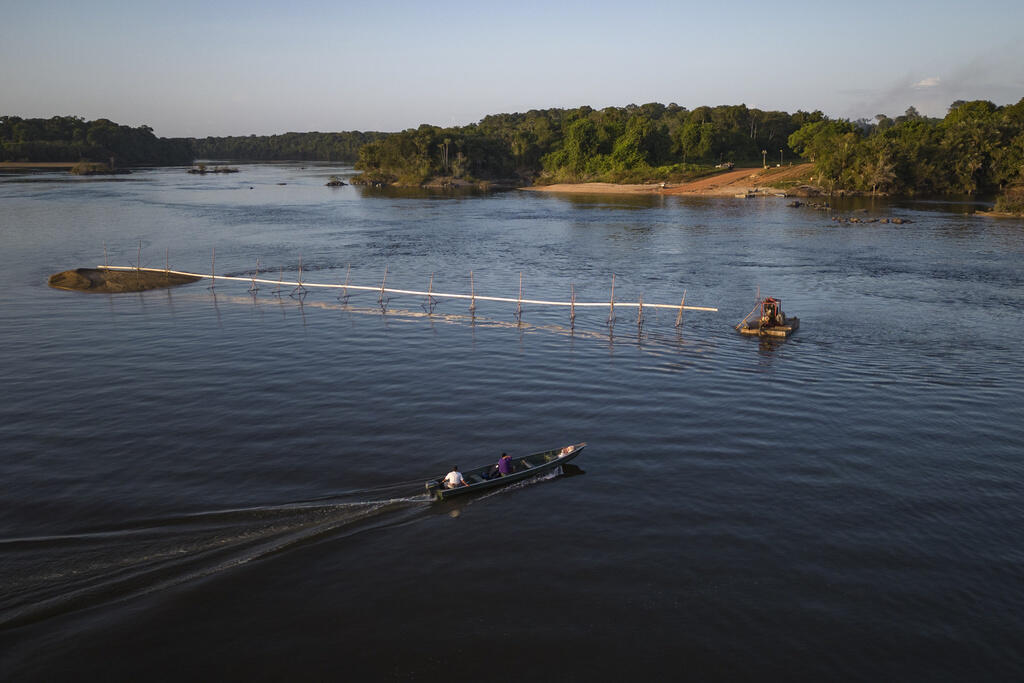 Pessoas navegam pelo rio Essequibo na travessia de Kurupukari, na Guiana, na segunda-feira, 10 de abril de 2023. A mais alta corte da ONU decidiu em 6 de março que pode ouvir um caso entre os países vizinhos Guiana e Venezuela sobre uma disputa de fronteira que remonta a 1899, já que a Venezuela alega que o rio é a verdadeira fronteira entre eles