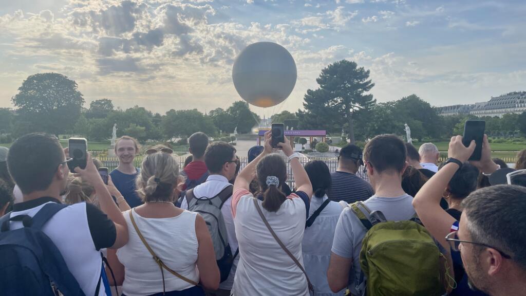 Visitantes e parisienses se aproximam da pira olímpica, instalada nos jardins de Tuileries durante o período dos Jogos de Paris 2024. 