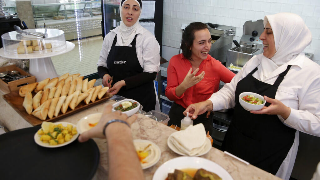Serenah Sabat, uma jovem palestina de 26 anos junto de Fatima Ghannam, à direita, e Rana, ambas da Síria, em um restaurante do Oriente Médio, onde trabalham em Lisboa.