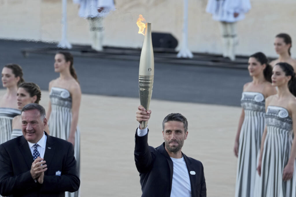O presidente do Comitê Organizador dos Jogos Paris 2024, Tony Estanguet, recebe a chama olímpica no Estádio Panatenaico de Atenas, em 26 de abril de 2024.