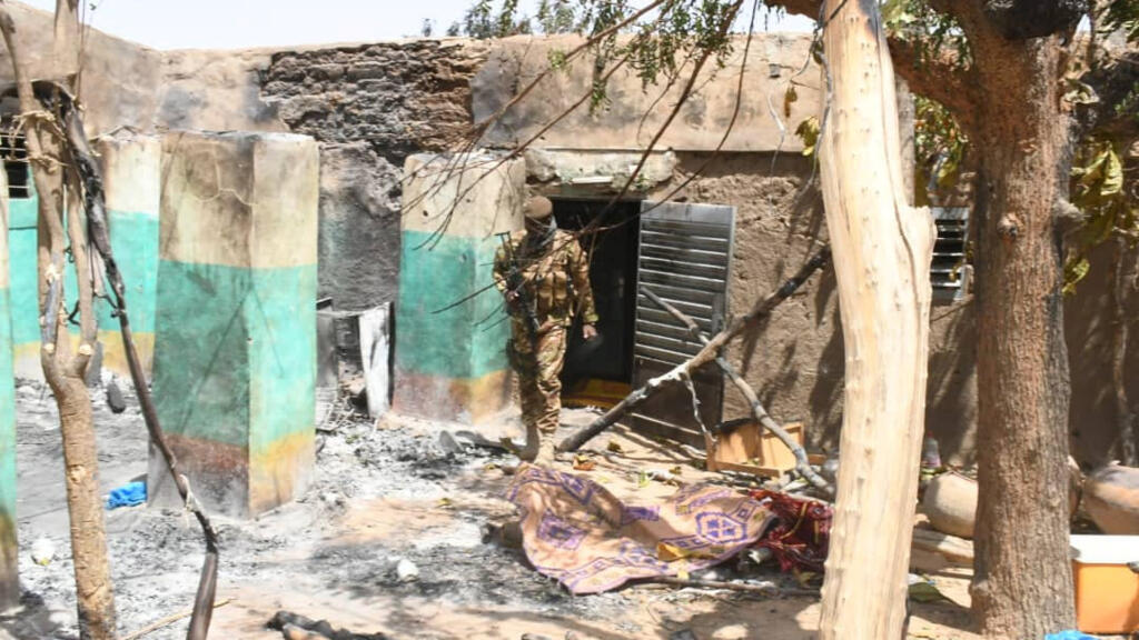 Un rapport onusien accuse l'armée malienne d'avoir "abandonné la population" du village d'Ogossagou, à la veille de l'attaque du 14 février 2020. Ici, un soldat dans les décombres d'Ogossagou, lors de la précédente attaque, en mars 2019.