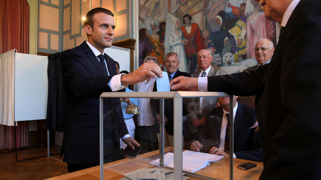 French President Emmanuel Macron casts his ballot as he votes at a polling station in the second round parliamentary elections in Le Touquet, France, June 18, 2017.