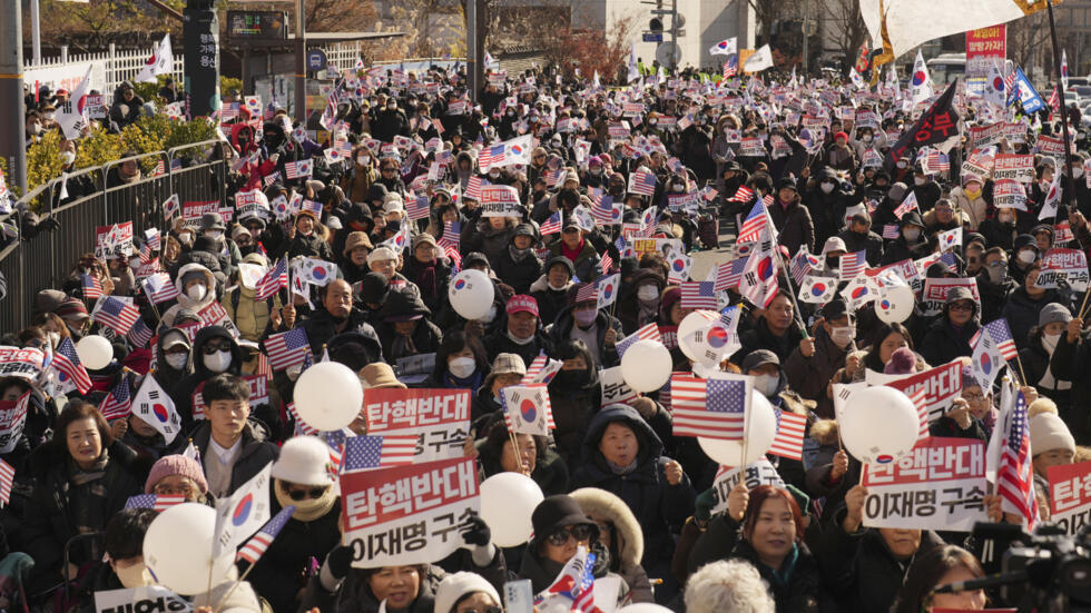 Supporters of impeached South Korean President Yoon Suk Yeol stage a rally near the presidential residence in Seoul, South Korea, Tuesday, Dec. 31, 2024. The letters read "Oppose Impeachment," and "Ar
