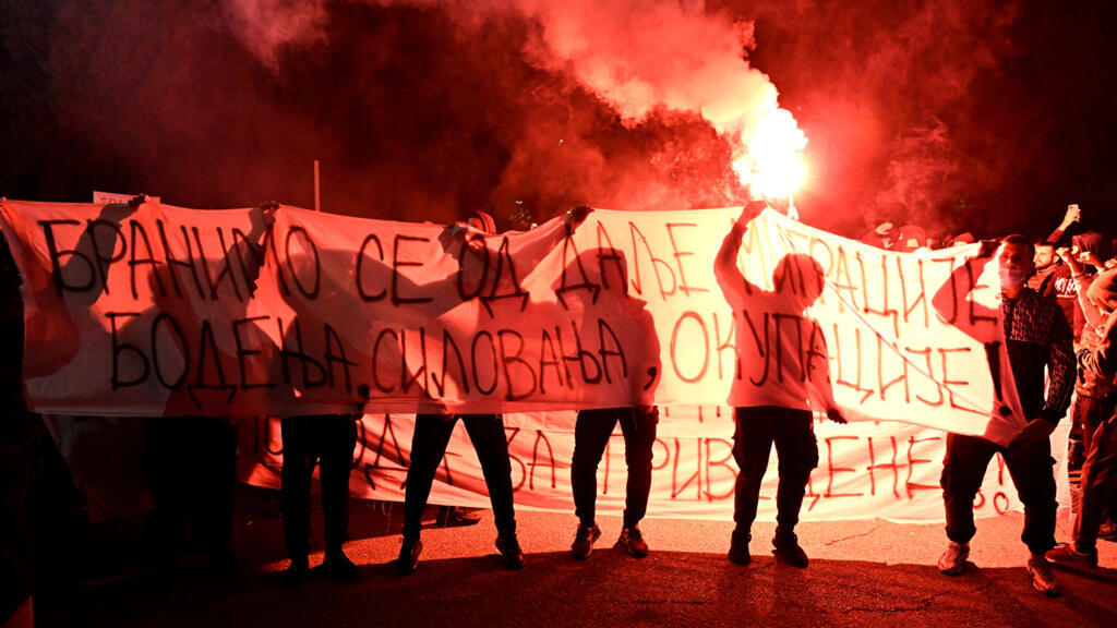 Demonstrators hold a banner reading "Defending ourselves from further migration, stabbings, rape and occupation" during protest in Montenegro's capital, Podgorica, on 28 October 2025, following the stabbing of a Montenegrin national.