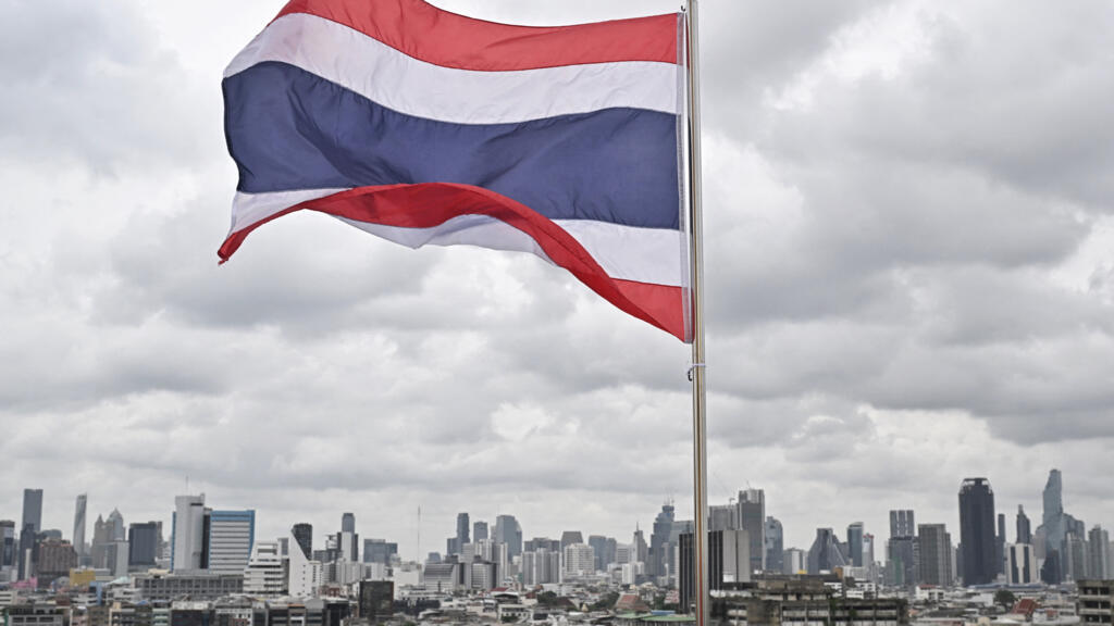Un drapeau thaïlandais est visible devant la silhouette de la ville depuis le sommet du temple bouddhiste Wat Saket à Bangkok, le 8 juillet 2025. Le Premier ministre thaïlandais par intérim a décidé de dissoudre le Parlement, a annoncé son parti le 3 septembre 2025, après que le principal parti d'opposition ait soutenu un candidat rival au poste de Premier ministre.