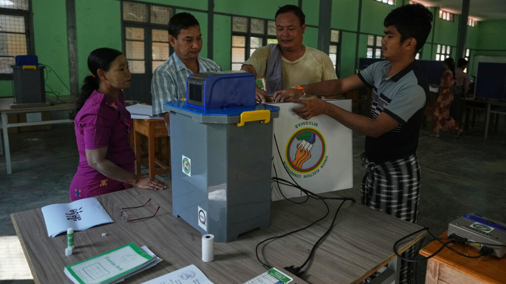 Des responsables et des volontaires de la Commission ��lectorale de l'Union se pr��parent �� installer des machines �� voter ��lectroniques dans un bureau de vote ouvert dans une ��cole �� Yangon, en Birmanie, la veille du premier tour des ��lections g��n��rales, le samedi 27 d��cembre 2025.