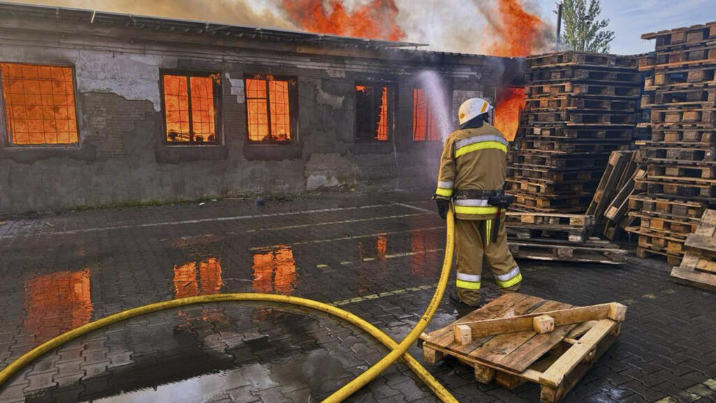 In this photo provided by the Ukrainian Emergency Service, a firefighter puts out the fire following a Russian attack in Kyiv region, Ukraine, Wednesday, July 9, 2025.