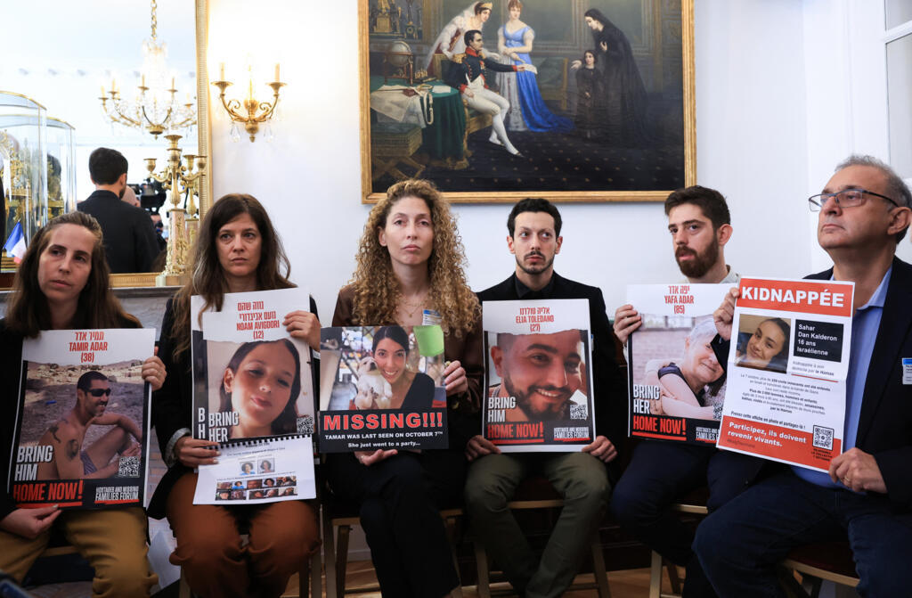 Parentes e conhecidos seguram fotos de pessoas desaparecidas ou mantidas como reféns, como Tamir Adar, Noam Avigdori, Tamar, Elia Toldano, Yafa Adar e Sahar Dan Kalderon, durante uma reunião com um grupo de famílias de reféns e pessoas desaparecidas do Hamas na Assembleia Nacional Francesa, em Paris, em 31 de outubro de 2023. (Foto de Emmanuel Dunand / AFP)