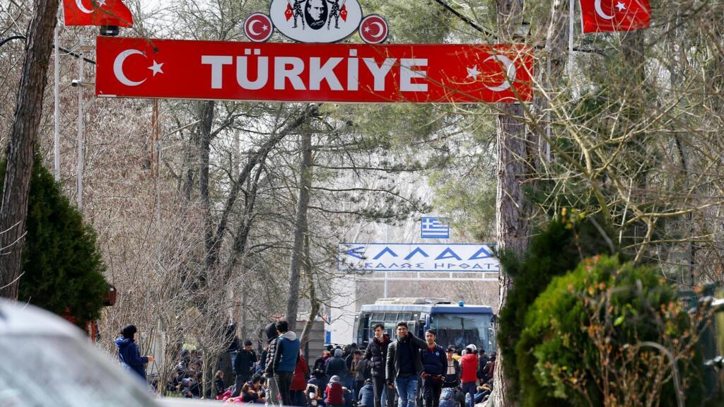 Un groupe de migrants attend dans le no man's land entre la Turquie et la Grèce, au poste frontière turc de Pazarkule avec la ville grecque de Kastanies, au nord du fleuve Evros, le 28 février 2020.