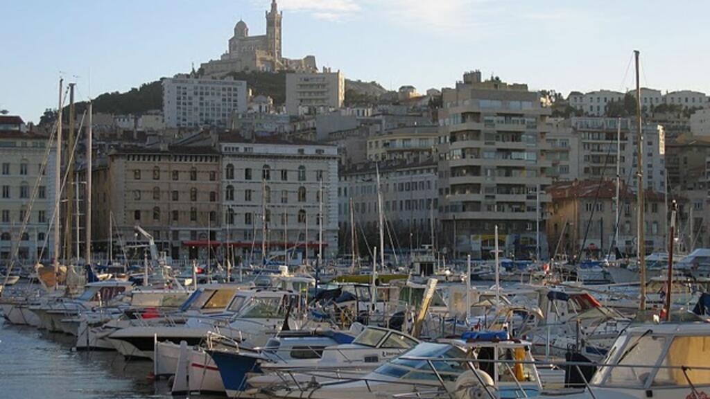 À Marseille, le Vieux Port et, en deuxième plan, la Basilique Notre-Dame de la Garde (surnommée «La Bonne Mère»).