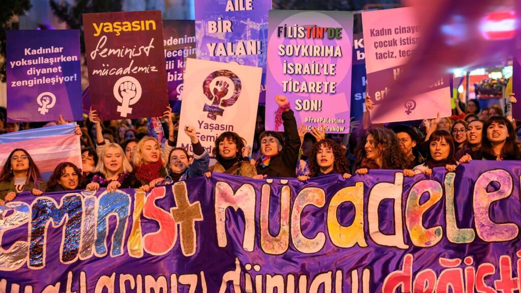 Des femmes brandissent des pancartes lors d'une marche marquant la Journée internationale des droits des femmes près de la place Taksim, à Istanbul, le 8 mars 2025.