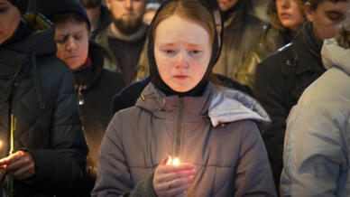 乌克兰军队志愿者、前克里姆林宫的政治犯根纳季-阿法纳西耶夫(Gennady Afanasiev)的亲朋在其灵柩旁祈祷2022年12月30日基辅