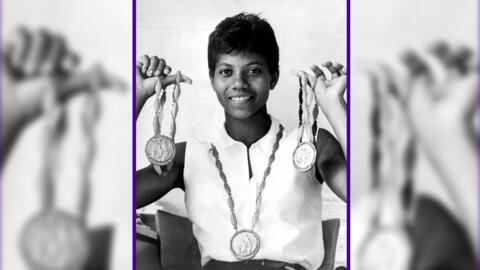 Wilma Rudolph brandit ses trois médailles d'or remportées lors des Jeux olympiques de 1960 pour avoir gagné le 200 mètres, le 100 mètres et le 4 x 100 mètres.