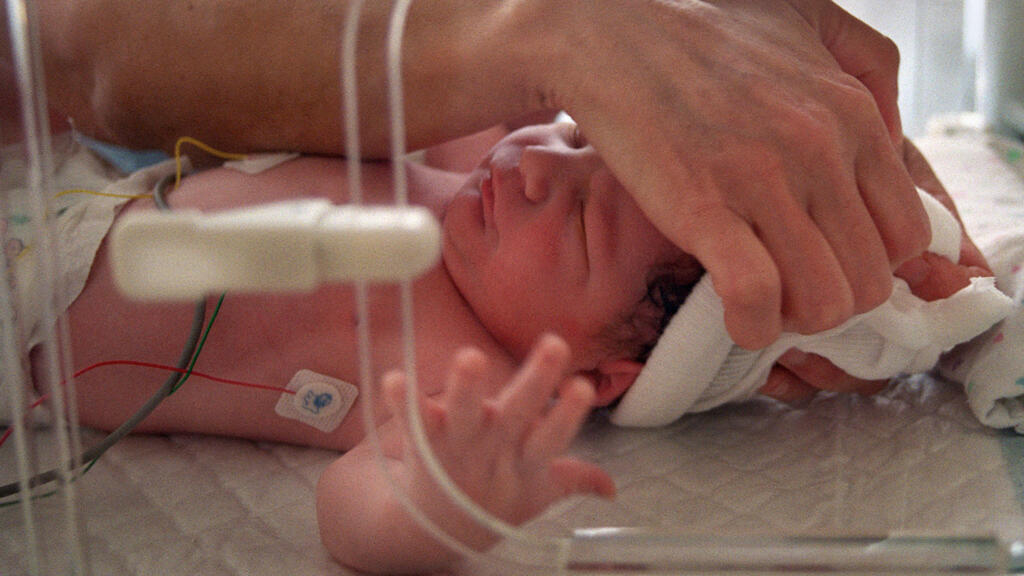 Une sage-femme s'occupe d'un nouveau-né placé en couveuse, juste après sa naissance, le 5 juin 2001 au service maternité de l'hôpital franco-britannique de Levallois-Perret.