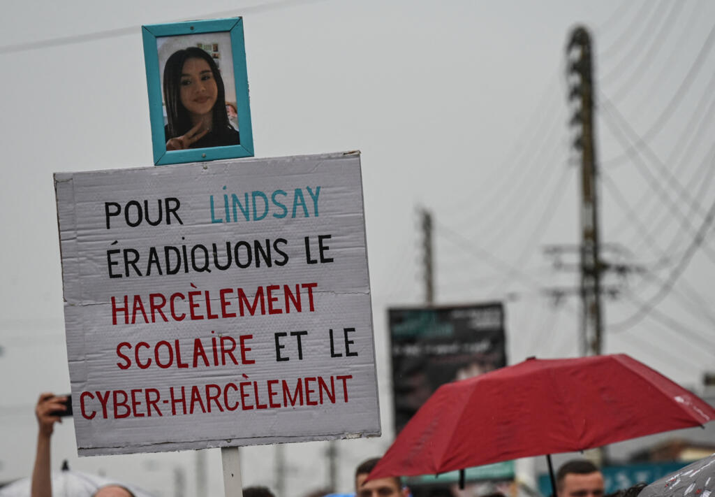 "Por Lindsay, vamos erradicar o assédio escolar e o cyberbullying" diz cartaz exibido durante uma marcha em homenagem a adolescente Lindsay, de 13 anos, que cometeu suicídio após ser assediada por colegas em Vendin-le-Vieil, norte da França, em 18 de junho de 2023.