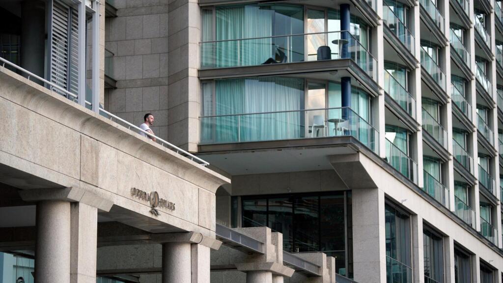 Un homme, depuis un balcon d'un immeuble près de l'Opéra de Sydney, suite à la mise en œuvre de règles plus strictes de distanciation sociale et de confinement pour limiter la propagation du coronavirus, à Sydney, en Australie, le 6 avril 2020.