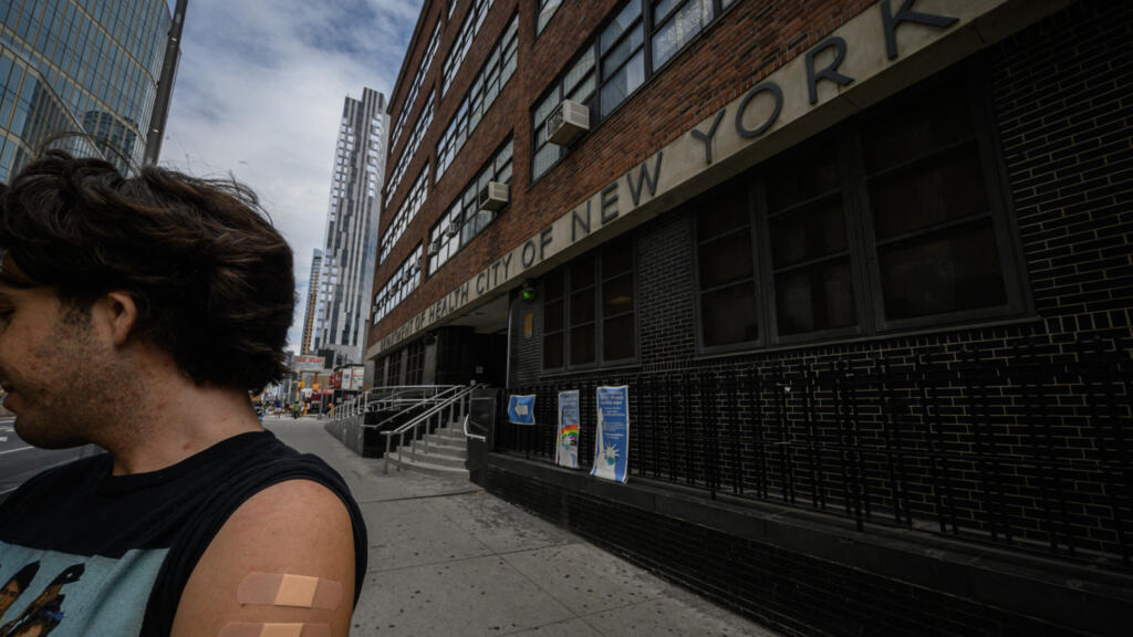 Un homme souhaitant garder l'anonymat montre son bras. Il vient d'être vacciné contre la poliomyélite à l'extérieur d'un centre médical de Brooklyn, à New York, le 17 août 2022.